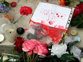 Candles and flowers are displayed at the makeshift memorial in front of the city hall after closed to the church where an hostage taking left a priest dead the day before in Saint-Etienne-du-Rouvray, Normandy, France, Wednesday, July 27, 2016.  (AP Photo/Francois Mori)