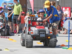 Bryson Lever-Kavanaugh, 6, looks both ways at a rail-way crossing at the Kids Safety Village put on by the Kingston and Cobourg police services in Spring Market Square in Kingston, Ont. on Wednesday July 27, 2016. Steph Crosier/Kingston Whig-Standard/Postmedia Network
