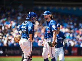 Blue Jays pitcher R.A. Dickey (right) talks to catcher Josh Thole before being pulled against the Padres during sixth inning MLB action in Toronto on Wednesday, July 27, 2016. (Aaron Vincent Elkaim/The Canadian Press)