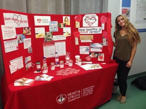 Submitted Photo 
Deanna Pinder, Heart Healthy Heat Wave Event Coordinator, stands in front of the Heart and Stroke's event display. The event will be coming to Belleville Thursday afternoon at Market Square in downtown Belleville.
