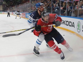 Cody Ceci of Canada in action with Leo Komarov of Finland. (REUTERS/Maxim Shemetov)