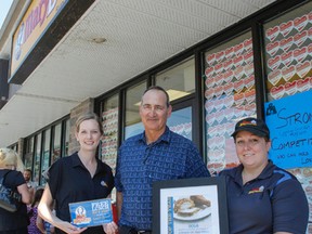 Robert Charest , centre, is the recipient of the first annual Mary Brown’s Citizen of the Year award for his work in helping to keep his community clean, outside the Hwy-15 franchise in Kingston, Ont. on Wednesday July 27, 2016. Charest was also awarded a voucher for free lunches for a year by franchise owner Caroline Dionne, right, and Kelly Masterson, local community marketing coordinator with Mary Brown’s Inc. Julia McKay/The Whig-Standard/Postmedia Network