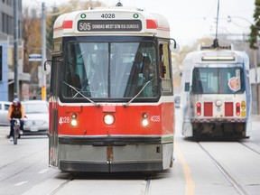 A cyclist rides next to a TTC streetcar in Toronto. (Toronto Sun files)