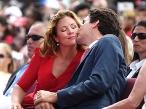 Prime Minister Justin Trudeau gives his wife Sophie Gregoire Trudeau a kiss during the Canada Day noon hour entertainment on Parliament Hill, in Ottawa on Friday, July 1, 2016. (THE CANADIAN PRESS/Justin Tang)