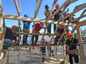 Students pose for a photo atop a unfinished greenhouse that have been taking part in a two-week construction camp at one of our District schools this summer, learning framing, roofing and glass installation in Edmonton Wednesday, July 27, 2016. They earn both high school and industry credentials as they build greenhouses like this one for charities.