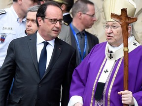 French President Francois Hollande (L) talks with French Cardinal Andre Vingt-Trois (R) after a Mass at the Notre Dame Cathedral in tribute to the priest Jacques Hamel, killed on July 26 in his church of Saint Etienne du Rouvray during a hostage-taking claimed by Islamic State group, in Paris on July 27, 2016. France probes an attack on a church in which two men described by the Islamic State group as its 'soldiers' slit the throat of a priest. An elderly priest had his throat slit in a church in northern France on July 26 after two men stormed the building and took hostages. The attack in the Normandy town of Saint-Etienne-du-Rouvray came as France was still coming to terms with the Bastille Day killings in Nice claimed by the Islamic State group. / AFP / DOMINIQUE FAGET (Photo credit should read DOMINIQUE FAGET/AFP/Getty Images)