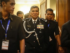 Malaysia's national police chief Khalid Abu Bakar smiles as he leaves after a press conference in Putrajaya, Malaysia, Thursday, July 28, 2016. Australian officials confirmed on Thursday that data recovered from a home flight simulator owned by the captain of Malaysia Airlines Flight 370 showed that someone had used the device to plot a course to the southern Indian Ocean, where the missing jet is believed to have crashed. (AP Photo/Joshua Paul)