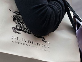 A customer leaves a Burberry shop with a bag bearing the store's logo in central London on September 11, 2012. Shares in luxury clothing and accessories group Burberry tumbled by almost 21 percent on September 11 after the British firm issued a surprise profits warning which analysts blamed on China's economic slowdown. (Will Oliver/AFP/GettyImages)