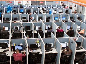 FILE - In this Aug. 13, 2014 file photo, workers sit at desks at a call center in the northern border city of Tijuana, Mexico. If you spend all day sitting, then you might want to schedule some time for a brisk walk - just make sure you can spare at least an hour. Scientists analyzing data from more than 1 million people found that it takes about 60 to 75 minutes of “moderate intensity” exercise to undo the damage of sitting for at least eight hours a day. Not exercising and sitting all day is as dangerous as being obese or smoking, they found. (AP Photo/Alex Cossio, File)