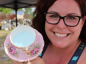 Samantha Reed/The Intelligencer
Belleville vendor Katie Kimball holds one of the many teacup candles for sale at her vendor tent on Thursday.