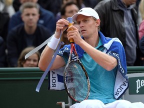 South Africa's Kevin Anderson rewraps his tennis grip during his men's first round match against France's Stephane Robert at the French Open in Paris on May 24, 2016. (AFP PHOTO/MARTIN BUREAU)