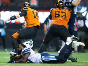Argos’ Shawn Lemon, losing his helmet trying tackle Lions' Travis Lulay,, says he is well aware, despite his short time in Ottawa, that veteran QB Henry Burris requires special defensive attention. (CP)