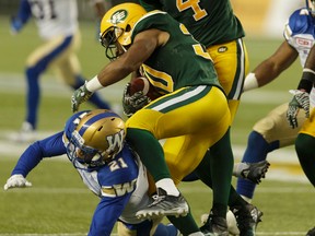 Edmonton's John White hurdles Winnipeg's Morgan Brendan during the first half of Thursday's game at Commonwealth Stadium. (Ian Kucerak)