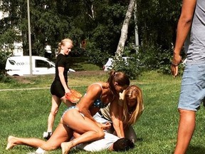 In this photo provided by Jenny Kitsune, Adolffson Swedish police officer Mikaela Kellner is pinning a man to the ground who is suspected to have stolen a friend's mobile phone as she said, in Stockholm Sweden, Wednesday, July 27, 2016. (Jenny Kitsune Adolfsson via AP)