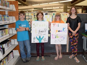 Jacob Sparks, Ashley Grimoldby, Samantha Jackson and Katelyn Grimoldby show the posters they made for their movie, The Spooky Library. The Reel Drama Club is doing the entire film themselves this summer.