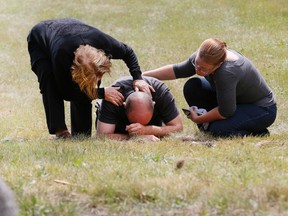 A father grieves for his daughter at the scene south of Orangeville where she was killed Tuesday, July 26, 2016 in a joyride crash. (Stan Behal/Toronto Sun)
