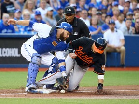 Russell Martin of the Toronto Blue Jays drops the ball while covering third base, allowing Manny Machado of the Baltimore Orioles to score at the Rogers Centre in Toronto, Ont. on Friday July 29, 2016. (Dave Abel/Toronto Sun/Postmedia Network)