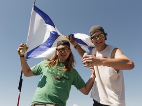 Nova Scotians Levi McMahon (left) and Curtis Bawn fly their province's flags proudly after 48 hours of driving to party at Big Valley Jamboree 2016 in Camrose, Alberta on Friday, July 29, 2016.