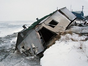 In this Dec. 8, 2006, file photo, Nathan Weyiouanna's abandoned house at the west end of Shishmaref, Alaska, sits on the beach after sliding off during a fall storm in 2005. Like some other Alaska villages, the Inupiat Eskimo community of 600 is facing an expensive relocation because of erosion, which is eating away at the current site on a narrow island just north of the Bering Strait. The community will hold a special election Aug. 16, 2016, asking residents if they should develop a new community at a nearby location or stay put with added protections. (AP Photo/Diana Haecker, File)
