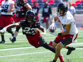 Redblacks DB Forrest Hightower just misses knocking the ball away as Brad Sinopoli makes a catch at practice. (Darren Brown/Postmedia Network)