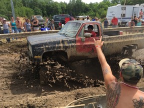 Spectators cheer as a pickup truck splashes through mud at an event formerly called the Redneck Olympics on Saturday, July 30, 2016, in Hebron, Maine. The organizer now calls the event the "Redneck Blank" after Olympic officials complained about the name. (AP Photo/David Sharp)