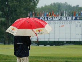 A man stands by the 18th hole after third round play at the PGA Championship was suspended for the day at Baltusrol Golf Club in Springfield, N.J., on Saturday, July 30, 2016. (Tony Gutierrez/AP Photo)