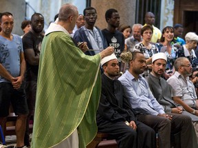 Muslims attend a Mass in Rome's Saint Mary in Trastevere church, Italy, Sunday, July 31, 2016. Imams and practicing Muslims attended Mass across Italy, from Palermo in the south to Milan in the north, in a sign of solidarity after the France church attack in which an elderly priest was slain. (Massimo Percossi/Ansa via AP)