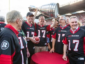 Ottawa Mayor Jim Watson, hoists the Grey Cup after the announcement that Ottawa will host the 2017 CFL Grey Cup game at TD Place Arena in Ottawa Sunday, July 31, 2016. (Darren Brown/Postmedia)