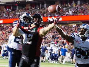 Toronto Argonauts' T.T. Heath and A.J. Jefferson battle with Ottawa Redblacks' Zack Evans for the ball during the first half of CFL action at TD Place Arena in Ottawa on July 31, 2016. (Darren Brown/Postmedia)