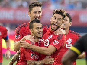 Teammates celebrate with Toronto F.C.'s Sebastian Giovinco, lower left, after he scored his first of two goals during first half MLS action against Columbus Crew S.C., in Toronto on Sunday, July 31, 2016. THE CANADIAN PRESS/Fred Thornhill