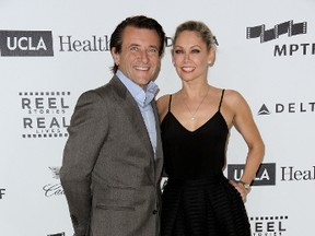 In this April 25, 2015, file photo, Robert Herjavec, left, and Kym Johnson arrive at the 4th Annual Reel Stories, Real Lives Benefit held at Milk Studios in Los Angeles. People magazine reported July 31, 2016, that the reality stars married in Los Angeles. (Photo by Richard Shotwell/Invision/AP, File)