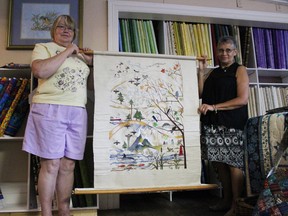 Diane Mugford, president of the Tulip Tree Needlearts of Chatham, (left) receives one panel of a tapestry designed for Canada's 150th birthday from Cori Angus, president of Norfolk's Own Needle Arts Guild (right), in Ingersoll on Monday, August 1, 2016. (MEGAN STACEY/Sentinel-Review)