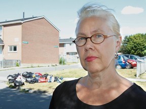 Barbara Muirhead, seen here on Monday August 1, 2016, in front of one of the smaller piles of garbage, and her neighbours are upset and want something done about the residential garbage that is constantly being piled up outside the Cliff Crescent townhouses a day or two before the scheduled day of city garbage collection. Julia McKay/The Whig-Standard/Postmedia Network