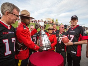 Various dignitaries, including Ottawa mayor Jim Watson, left, and OSEG’s Roger Greenberg, far right, stand by the Grey Cup after the announcement that Ottawa will host the 2017 CFL Grey Cup game at TD Place Arena in Ottawa Sunday, July 31, 2016. (Darren Brown/Postmedia)