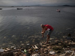 A man washes himself in the polluted waters of Guanabara Bay in Rio de Janeiro, Brazil, Saturday, July 30, 2016. While local authorities including Rio Mayor Eduardo Paes have acknowledged the failure of the city’s water cleanup efforts, calling it a “lost chance” and a “shame,” Olympic officials continue to insist Rio’s waterways will be safe for athletes and visitors. (AP Photo/Felipe Dana)