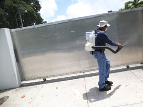 Larry Smart, a Miami-Dade County mosquito control inspector, uses a fogger to spray pesticide to kill mosquitos in the Wynwood neighborhood as the county fights to control the Zika virus outbreak on August 1, 2016 in Miami, Florida. Today, it was announced that 10 more individuals have been infected with the Zika virus by local mosquitoes.  (Photo by Joe Raedle/Getty Images)
