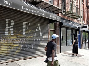 In this July 28, 2016 photo, people walk by the Renaissance Fine Art gallery and Long Gallery in New York's Harlem neighborhood. The neighborhood already is home to about a dozen galleries. In the fall it's getting two more, transplants from Lower Manhattan. (AP Photo/Richard Drew)