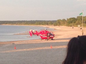 A STARS air ambulance landed at Grand Beach on Aug. 1, 2016, to transport two people pulled from the water. RCMP have confirmed two people died in the incident. (COTTAGE RENTALS/TWITTER PHOTO)