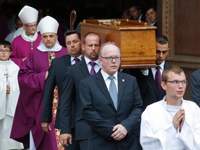 The coffin of Father Hamel is carried out of the Rouen cathedral, Normandy, after his funeral mass, Tuesday, Aug.2, 2016. Father Jacques Hamel, 85, was killed by two Islamic extremists last week in his church as he celebrated morning Mass. The Islamic State group claimed responsibility for the attack. (AP Photo/Michel Euler)