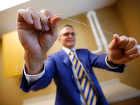 Dr. Wayne Aldredge, president of the American Academy of Periodontology, holds a piece of dental floss at his office in Holmdel, N.J. Aldredge acknowledges the weak scientific evidence and the brief duration of many studies on flossing, but says that the impact of floss might be clearer if researchers focused on patients at the highest risk of gum disease, such as diabetics and smokers. (AP Photo/Julio Cortez)
