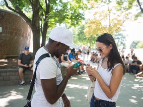 Adrian Thomas and Caitlin Huynh are pictured playing Pokemon Go at Toronto's Jack Layton Ferry Terminal. (ERNEST DOROSZUK, Toronto Sun)