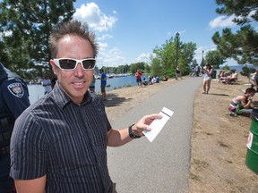 Miles Hammond is a member of the Nepean Sailing Club who received a parking ticket for parking on the grass at Dick Bell Park on Monday. Members of the club and Pokémon Go players, seen here in the background, have been competing for parking spots at the park, which has been a popular spot for catching Pokemon. Wayne Cuddington/Postmedia