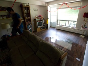A resident walks through a partially flooded living room nearly twenty four hours after heavy rain left several units of a three storey walkup at 1170 Adelaide Street North with ankle-deep water throughout in London. (CRAIG GLOVER, The London Free Press)