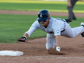 London Majors runner Chris McQueen reaches for the safety of first base during an Intercounty Baseball League game at Labatt Park in London. (CRAIG GLOVER, The London Free Press)