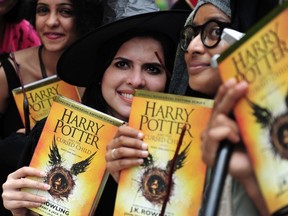 Fans pose for phootgraphers with copies of J.K. Rowlings new book "Harry Potter and the Cursed Child' during an event to mark the book launch at a mall in Chennai on July 31, 2016. AFP PHOTO / ARUN SANKARARUN SANKAR/AFP/Getty Images
