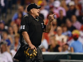 Home plate umpire Bob Davidson points into the crowd at an unruly fan during the sixth inning of a game between the Phillies and Giants in Philadelphia on Tuesday, Aug. 2, 2016. (Derik Hamilton/AP Photo)