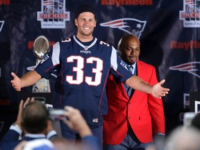 New England Patriots quarterback Tom Brady, center, wears a Kevin Faulk jersey while speaking during a Patriots Hall of Fame induction ceremony for Faulk, right, at Gillette Stadium, Monday, Aug. 1, 2016, in Foxborough, Mass. (AP Photo/Steven Senne)