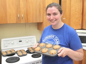 Counsellor Emily Corkey shows the day's snack during a summer cooking camp in Kingston on Wednesday. The children learn about healthy eating habits and help prepare their own lunches. (Michael Lea/The Whig-Standard)