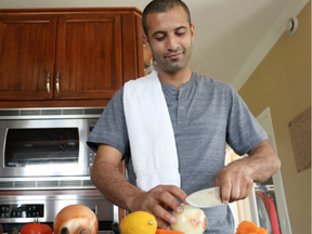 Ahmad Altaouil, a Syrian chef who recently came to Canada, chops onions (Evelyn Harford, Postmedia)