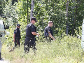 Greater Sudbury Police Service officers perform a grid search on a property on  Lumsden Road in Blezard Valley in Greater Sudbury, Ont. on Wednesday August 3, 2016. At approximately 6:30 pm, on Tuesday, Greater Sudbury Fire Services responded to a call of a structure fire on Lumsden Road, Blezard Valley. Once the fire was extinguished, a body was discovered in the ruins of the fire. Gino Donato/Sudbury Star/Postmedia Network